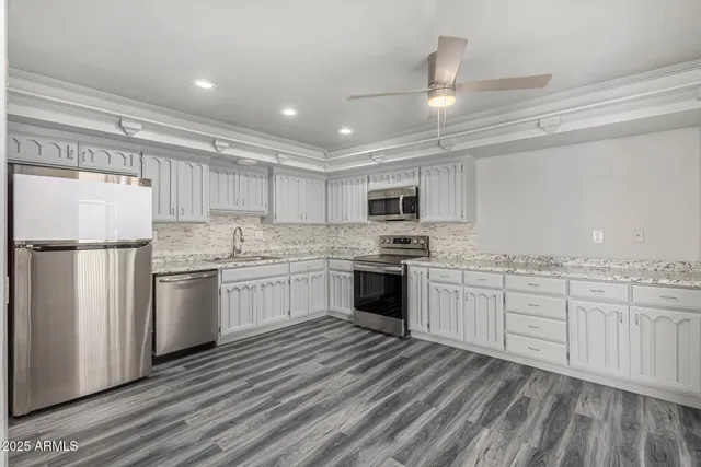 a kitchen with granite countertop stainless steel appliances and white cabinets