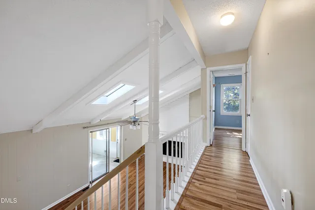 a view of a hallway with wooden floor and staircase