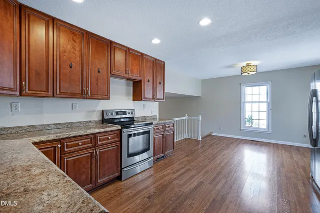 a kitchen with wooden floors and wooden cabinets