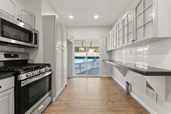 a kitchen with stainless steel appliances a stove a sink and a microwave