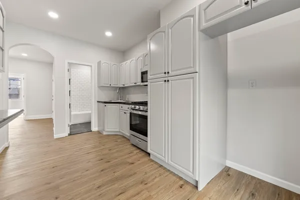 a kitchen with white cabinets and white appliances