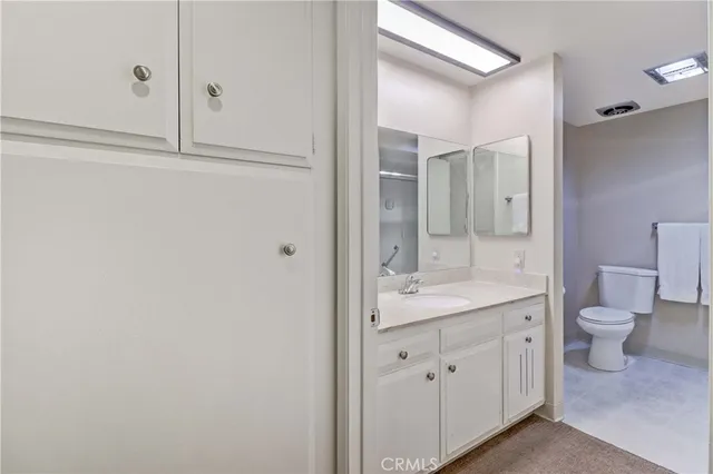 a bathroom with a granite countertop sink mirror and toilet