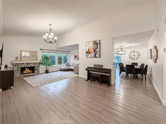 a view of a livingroom with furniture a chandelier and wooden floor