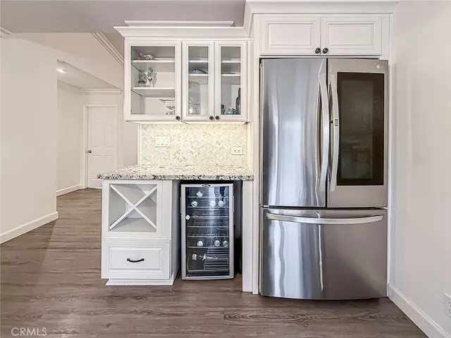 an empty room with wooden floor and cabinet