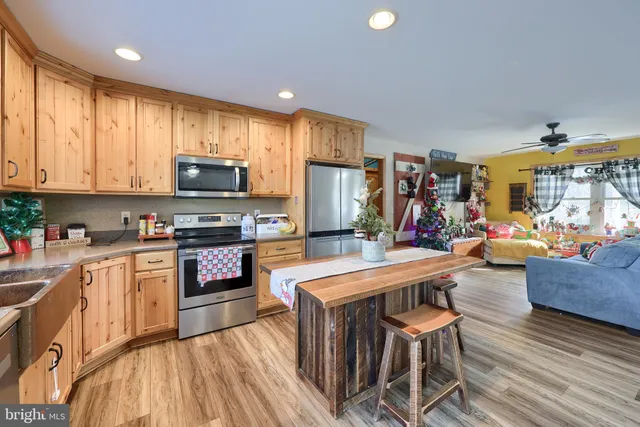 a kitchen with sink refrigerator dining table and chairs