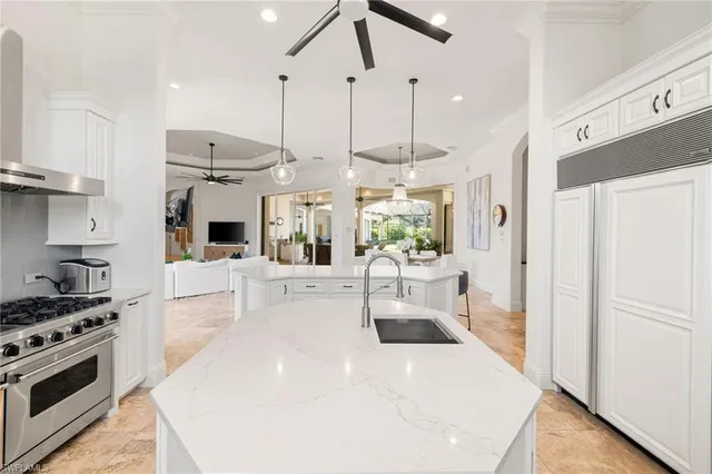 a kitchen with stainless steel appliances kitchen island granite countertop a table and chairs in it