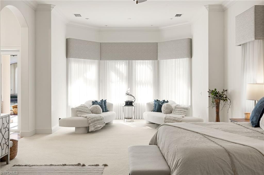 185 Tupelo Road Naples, FL 34108 - Photo 20 of 44 a bedroom with furniture and large windows