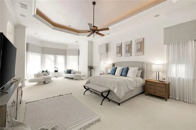 a bedroom with furniture and large windows