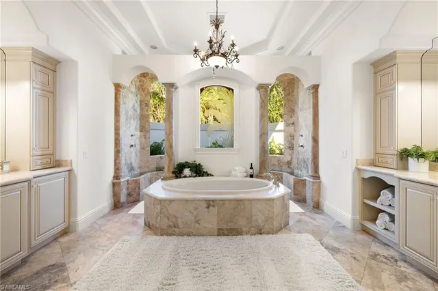 a spacious bathroom with a granite countertop tub a double vanity sink and a mirror