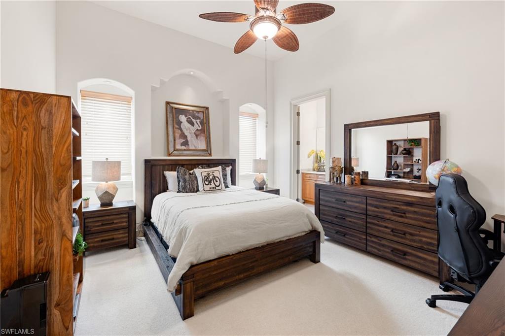185 Tupelo Road Naples, FL 34108 - Photo 31 of 44 a bedroom with a bed and a chandelier