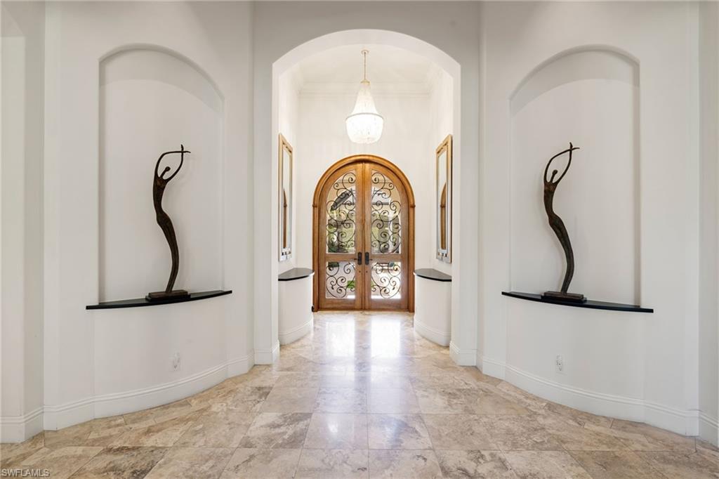 185 Tupelo Road Naples, FL 34108 - Photo 8 of 44 a view of a hallway with entryway wooden floor and front door
