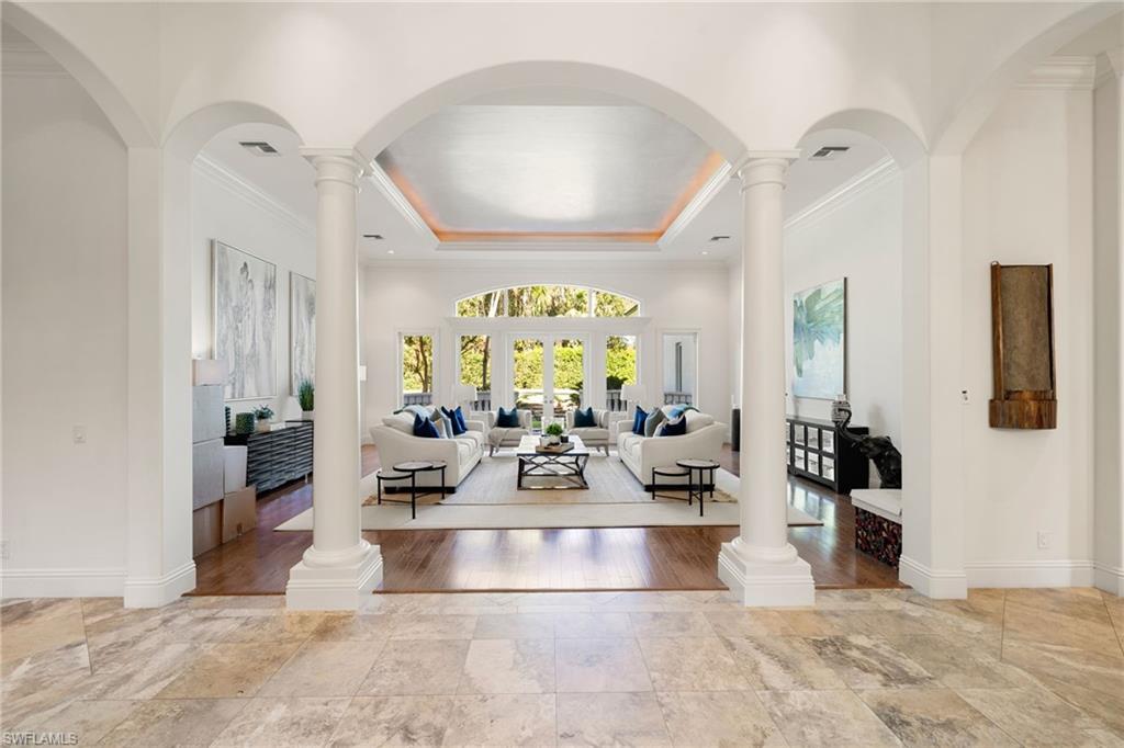 185 Tupelo Road Naples, FL 34108 - Photo 9 of 44 a room with lots of white furniture and a large mirror