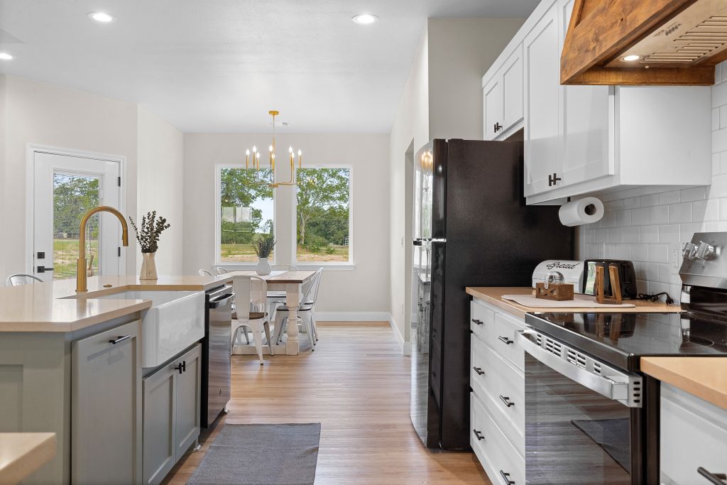 Gleaming hardwood floors and a wooden range hood anchor this bright culinary space.