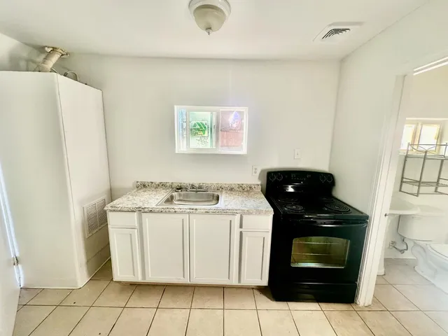 a kitchen with a stove top oven and cabinets