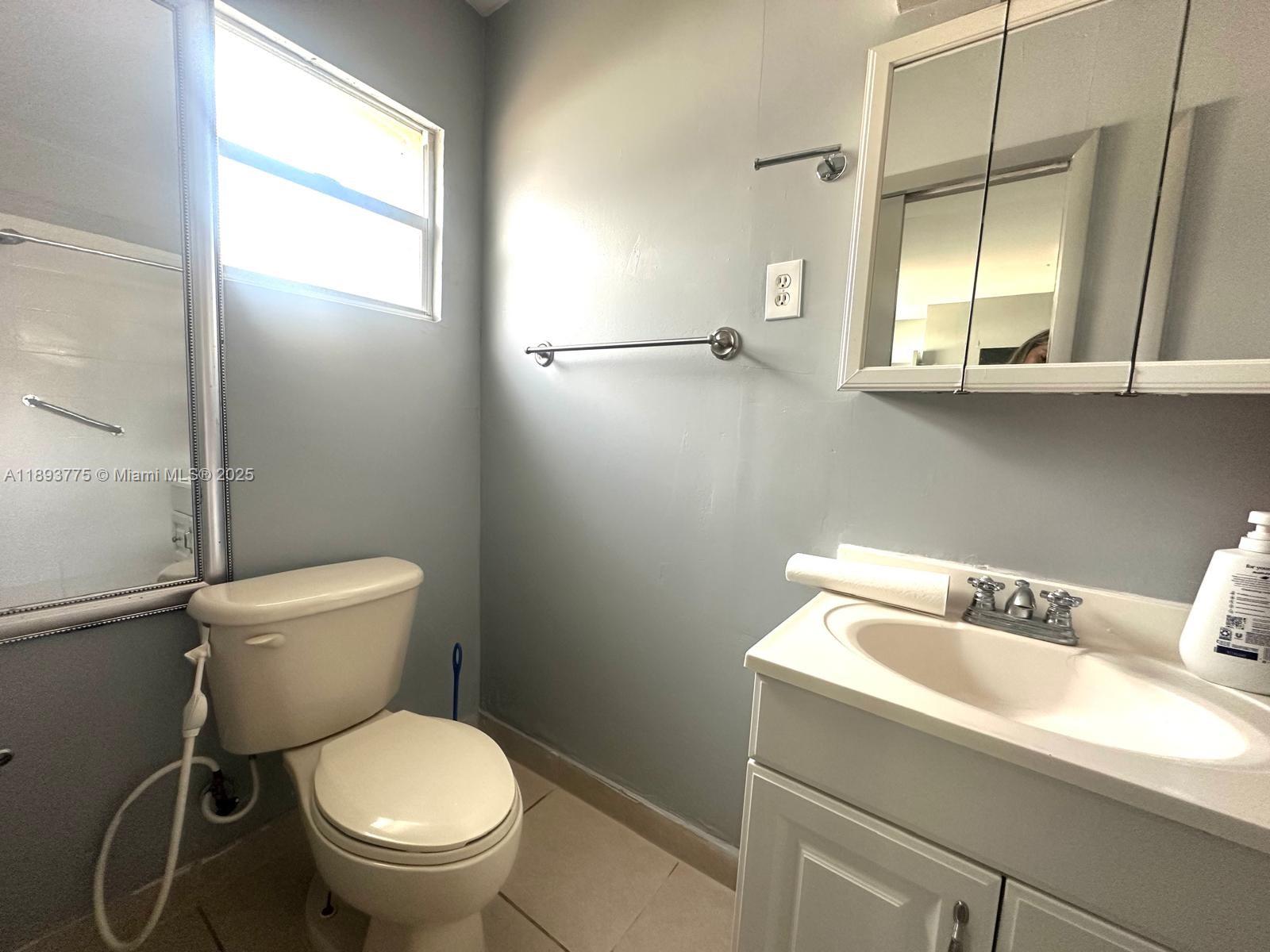 4361 Southwest 3rd Street, Unit 1 Miami, FL 33134 - Photo 6 of 11 a white toilet sitting next to a bathroom sink