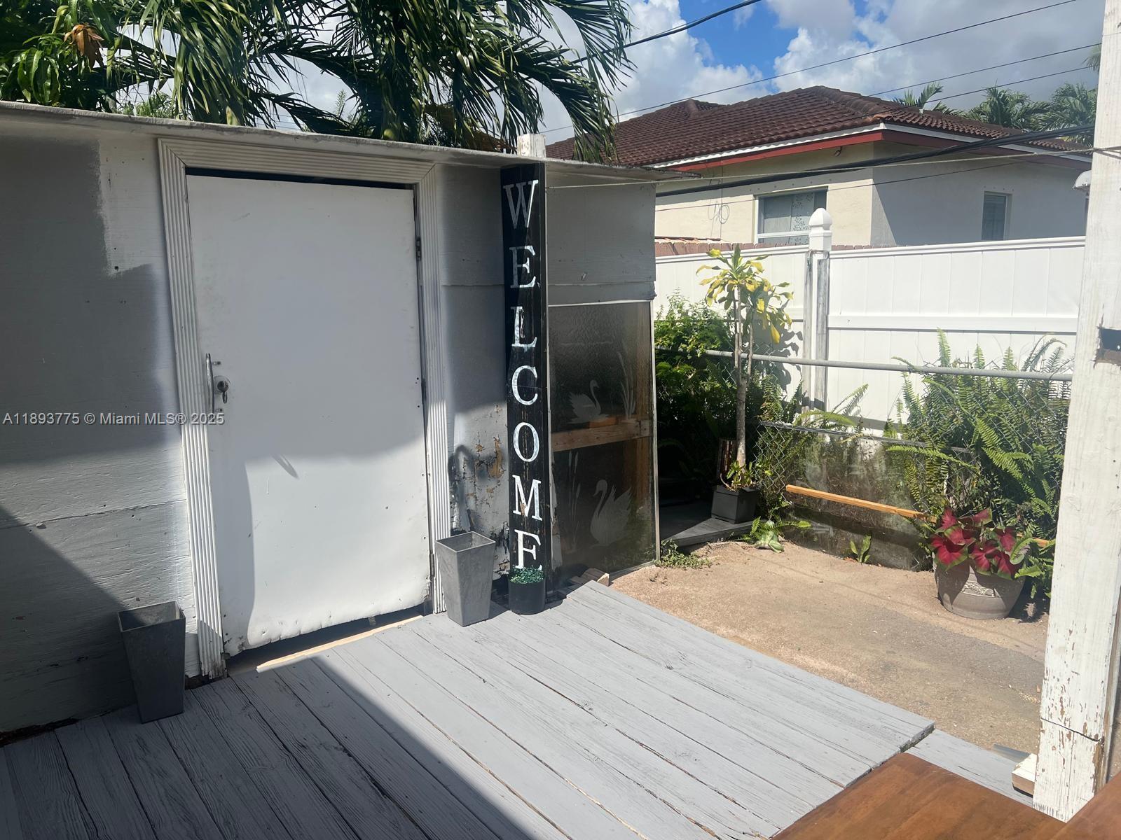 4361 Southwest 3rd Street, Unit 1 Miami, FL 33134 - Photo 9 of 11 a backyard of a house with wooden floor table and chairs