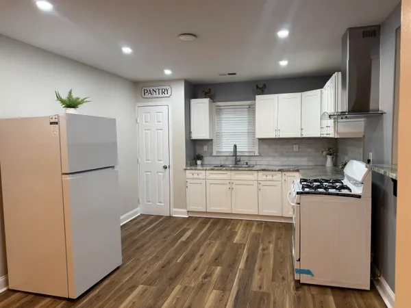a kitchen with a refrigerator a stove top oven a sink and cabinets