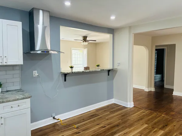 a view of kitchen with granite countertop cabinets and wooden floor