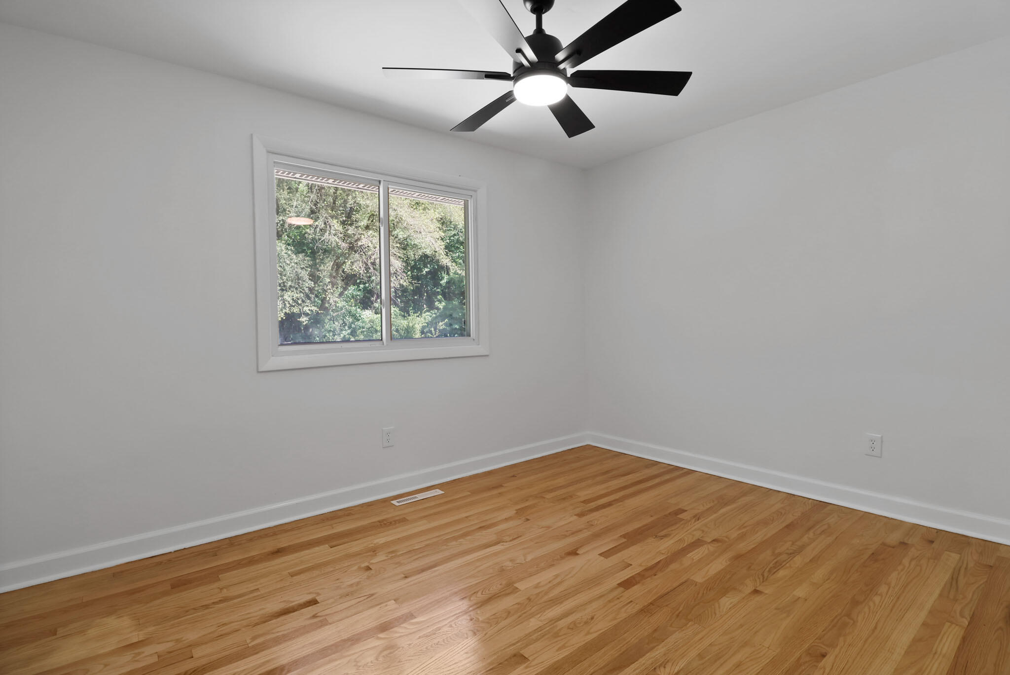 1564 Clinton Street Gary, IN 46406 - Photo 14 of 27 a view of an empty room with wooden floor and a window