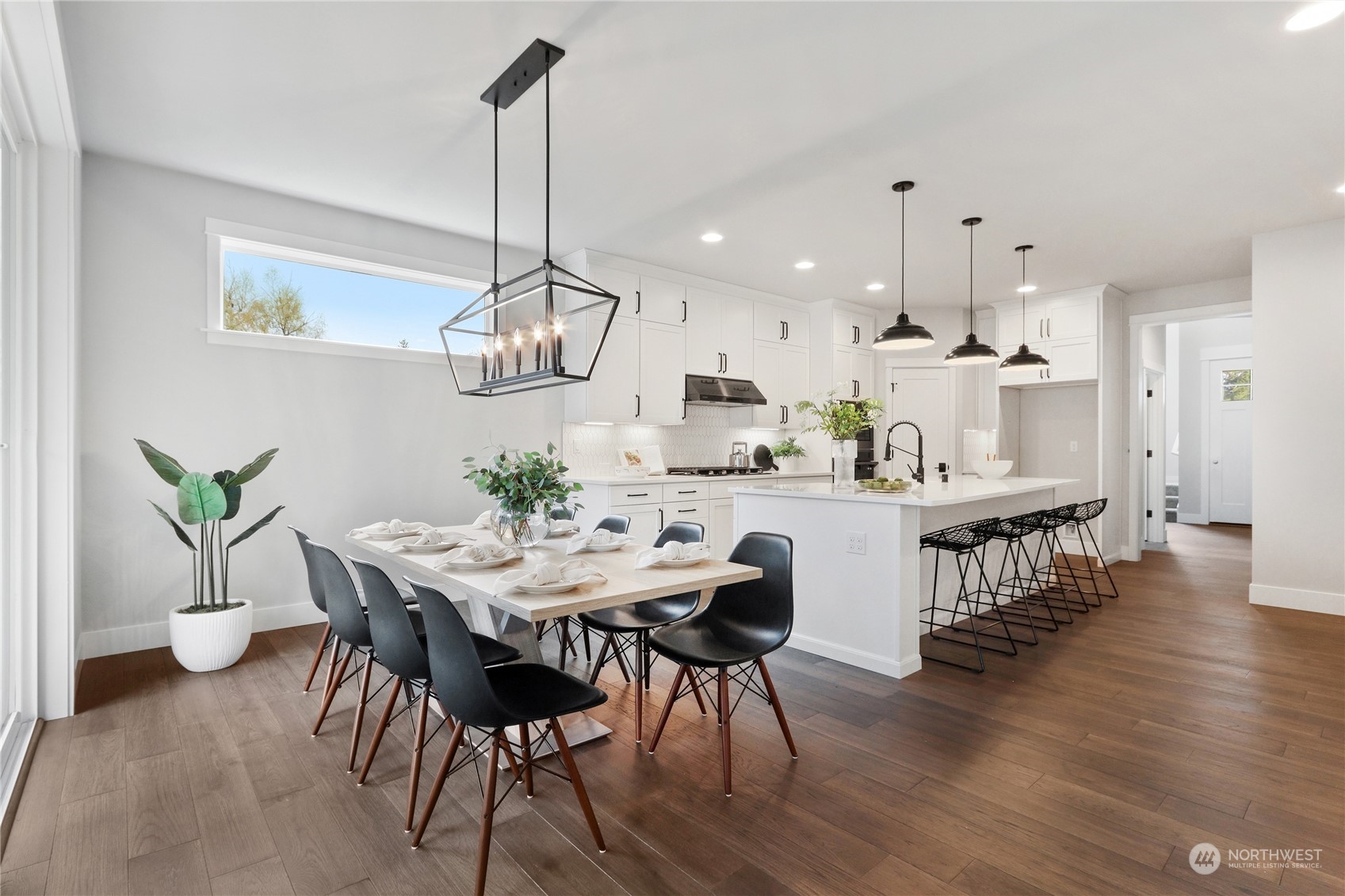 3904 211th Place Southeast Bothell, WA 98021 - Photo 4 of 24 a kitchen with kitchen island stainless steel appliances a dining table chairs stove and wooden floor