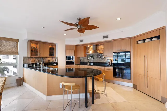 a kitchen with stainless steel appliances granite countertop a refrigerator a sink a stove and white cabinets