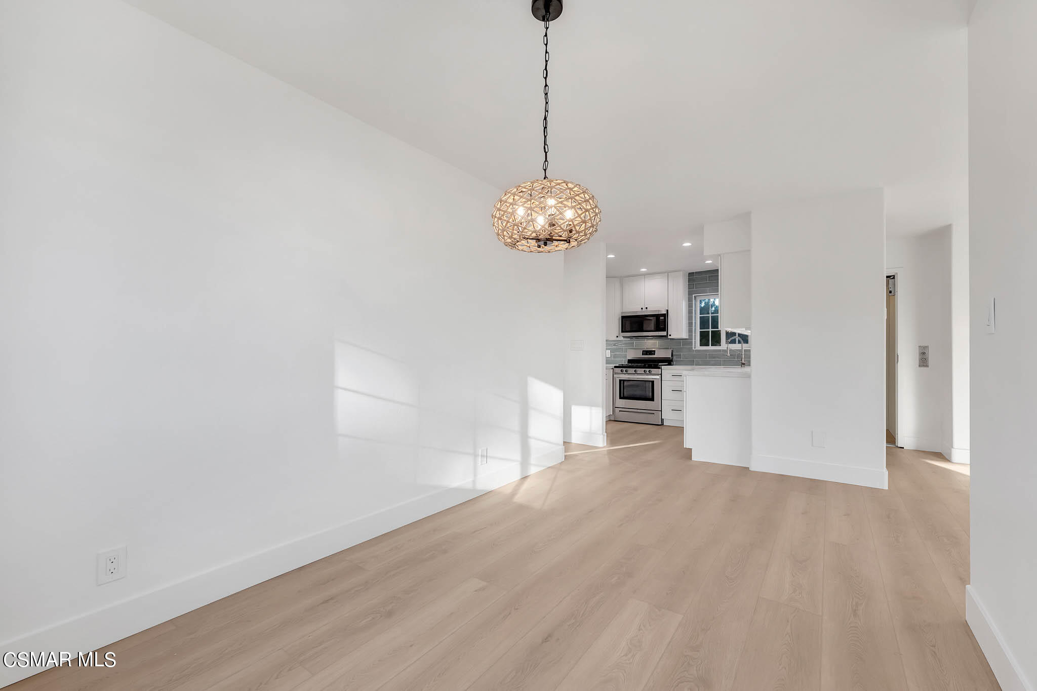 5222 West Wooley Road Oxnard, CA 93035 - Photo 13 of 39 a view of a kitchen with a sink a refrigerator and wooden floor