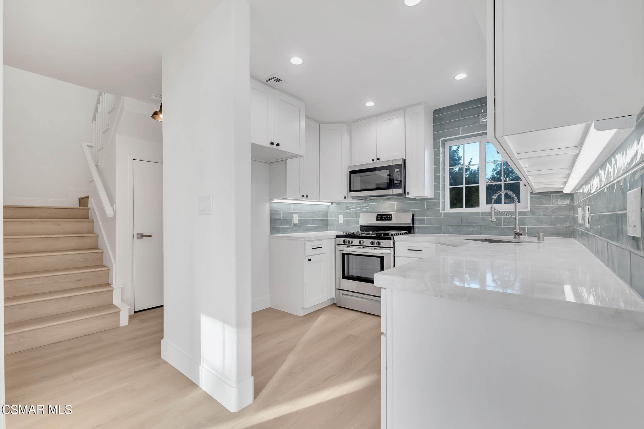 5222 West Wooley Road Oxnard, CA 93035 - Photo 15 of 39 a kitchen with white cabinets and stainless steel appliances