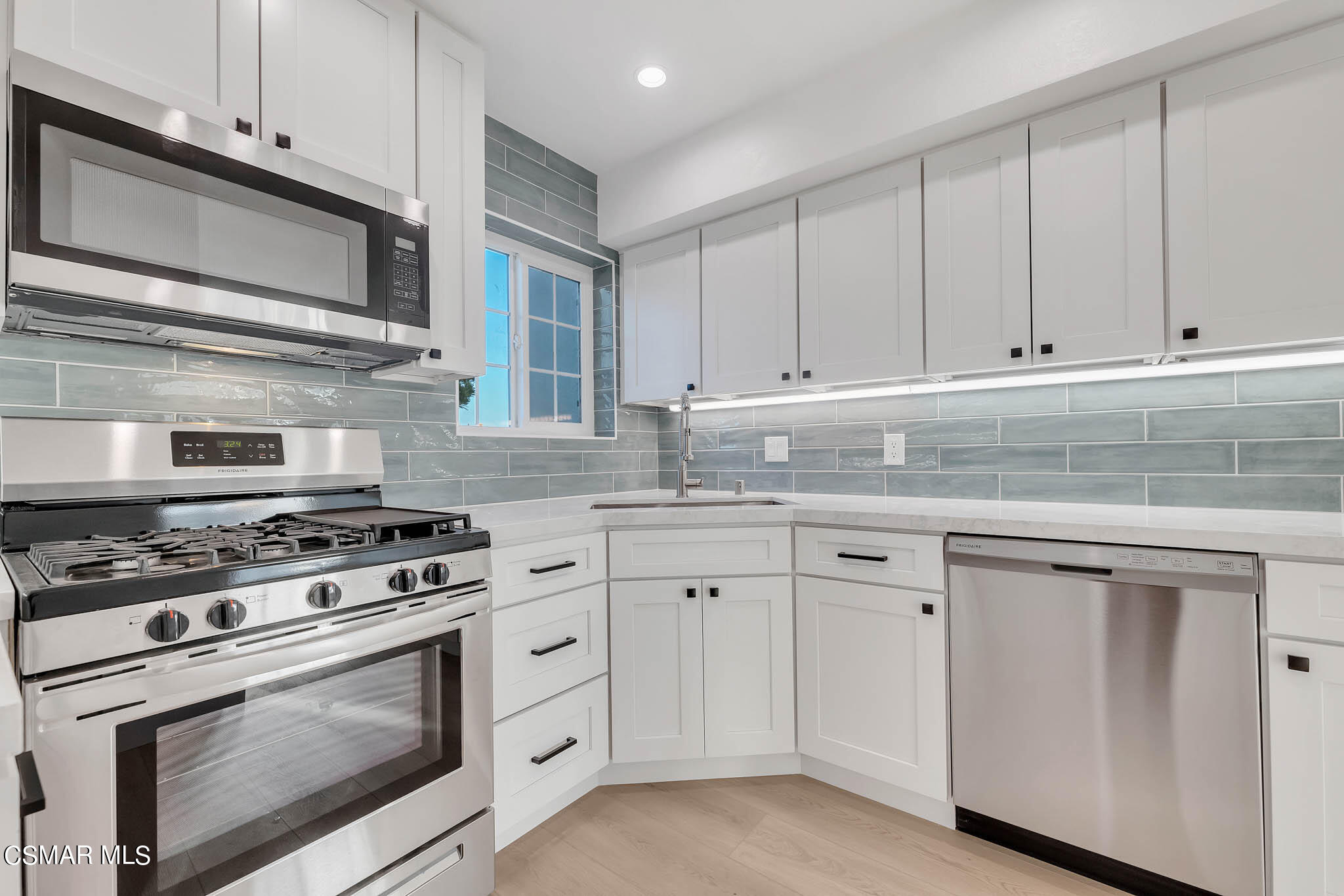 5222 West Wooley Road Oxnard, CA 93035 - Photo 16 of 39 a kitchen with granite countertop white cabinets and stainless steel appliances