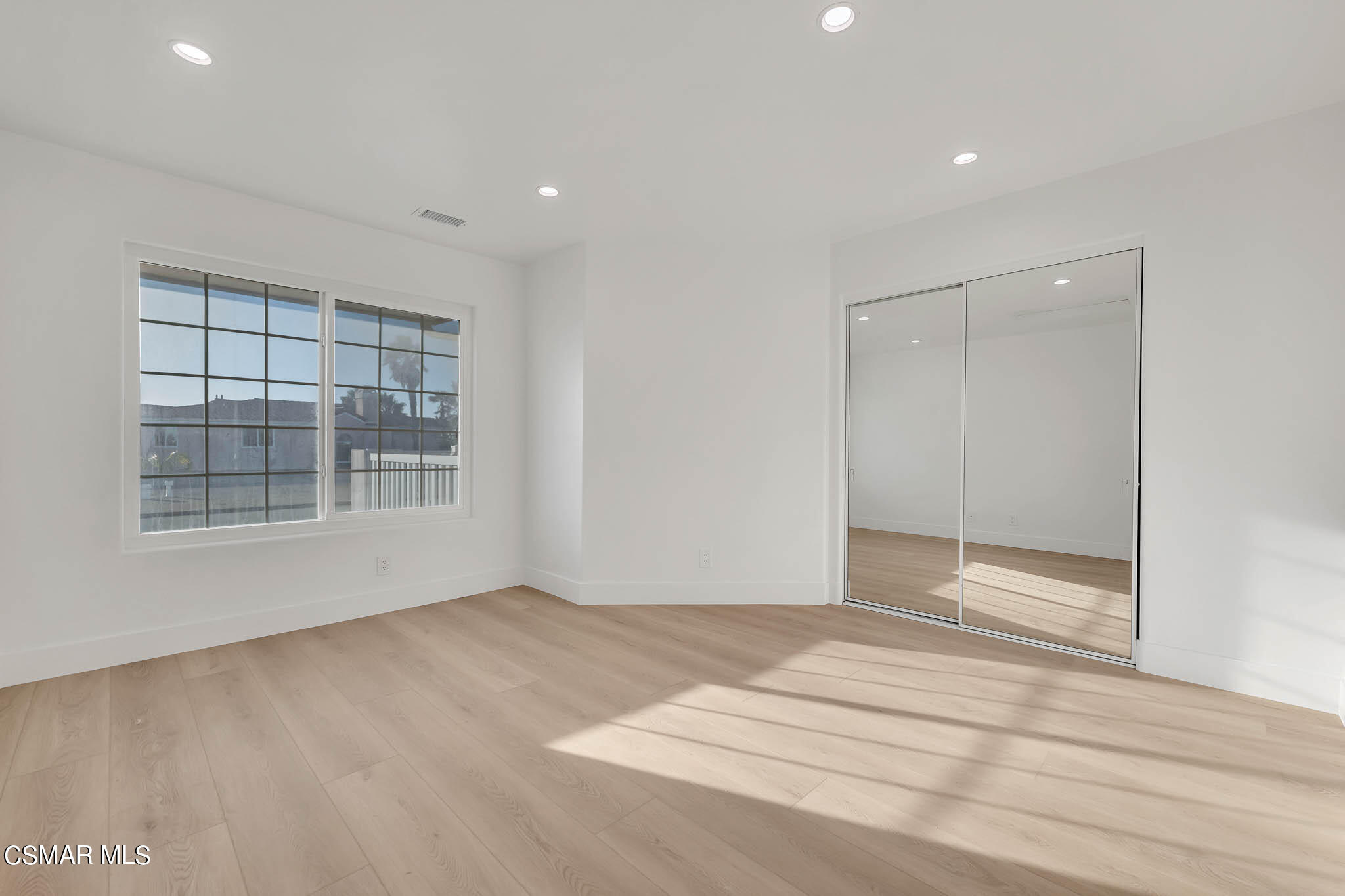 5222 West Wooley Road Oxnard, CA 93035 - Photo 19 of 39 a view of an empty room with wooden floor and a window