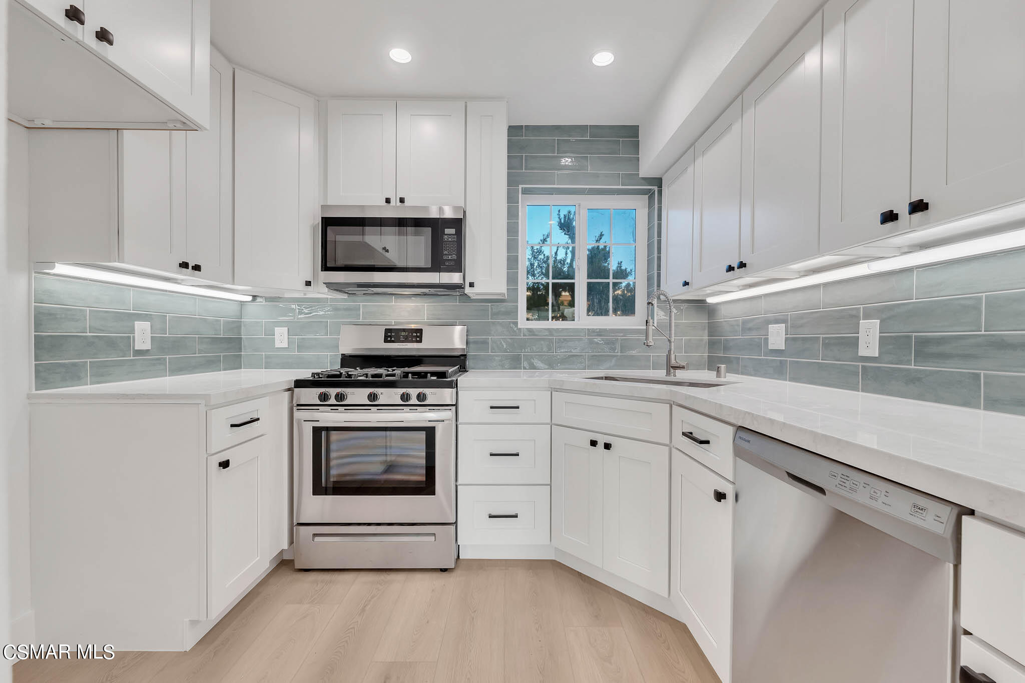 5222 West Wooley Road Oxnard, CA 93035 - Photo 3 of 39 a kitchen with granite countertop white cabinets and stainless steel appliances