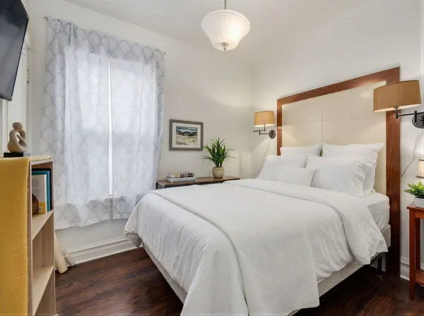 a bedroom with a bed and a painting on the wall