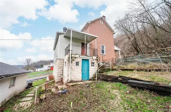 a view of a house with a yard and sitting area