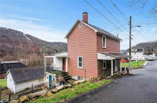 a view of a house with a yard and sitting area