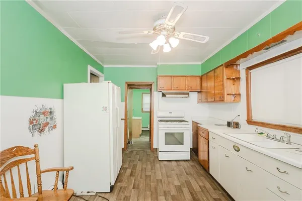 a kitchen with a refrigerator a sink dishwasher and a stove with wooden floor