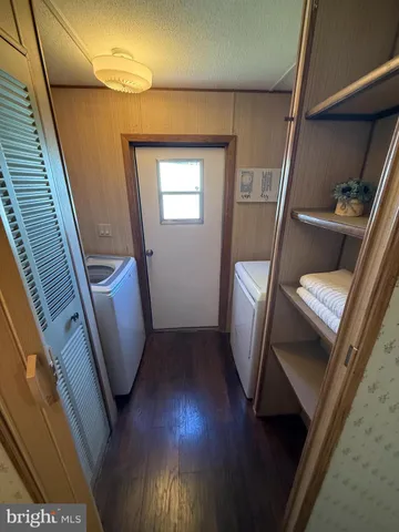 a view of an empty room with wooden floor and chair