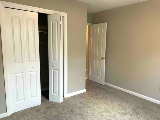 an empty room with windows and closet