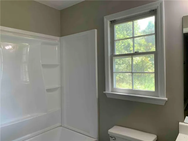 a white toilet sitting next to a window