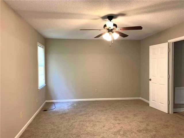 a view of a chandelier fan and window in an empty room