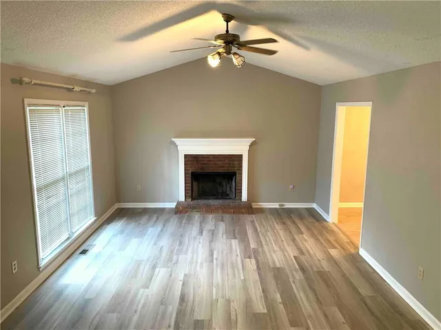 an empty room with windows and a fireplace