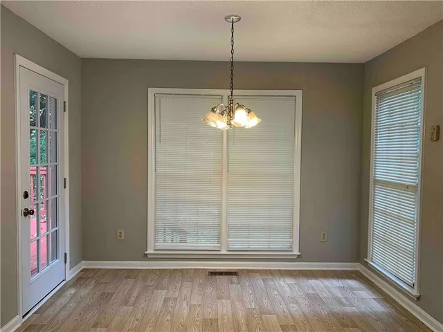 a view of a room with wooden floor and windows