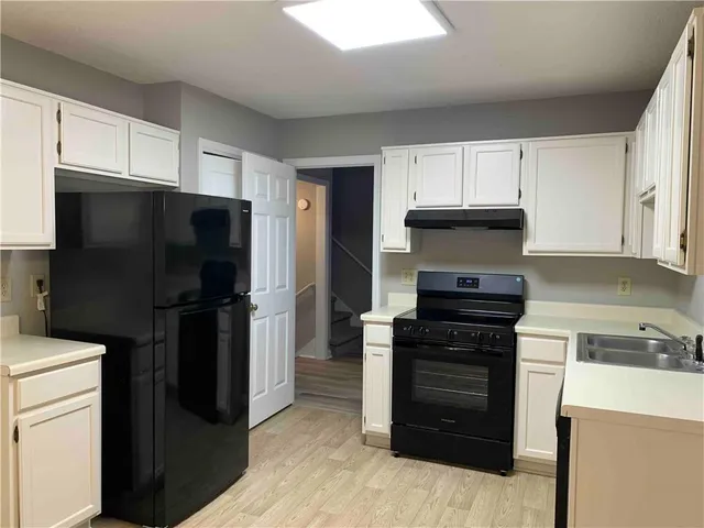 a kitchen with a refrigerator stove and cabinets