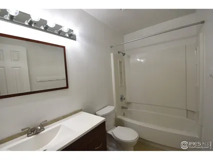 a bathroom with a sink a toilet a mirror and shower