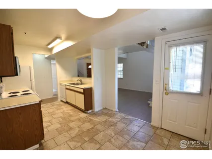 a kitchen view with granite countertop a stove a sink and a refrigerator