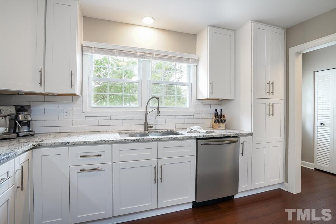 1318 Springlawn Court Raleigh, NC 27609 - Photo 10 of 30 a kitchen with stainless steel appliances granite countertop white cabinets and a window