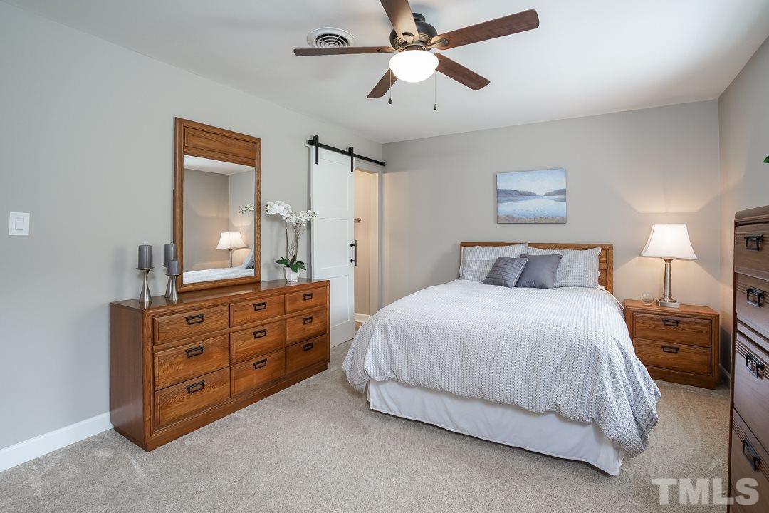 1318 Springlawn Court Raleigh, NC 27609 - Photo 16 of 30 a bedroom with a bed and a chandelier