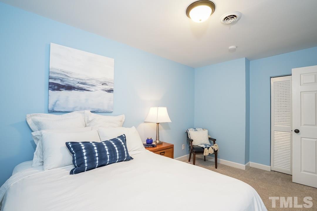 1318 Springlawn Court Raleigh, NC 27609 - Photo 19 of 30 a bedroom with a bed and a lamp