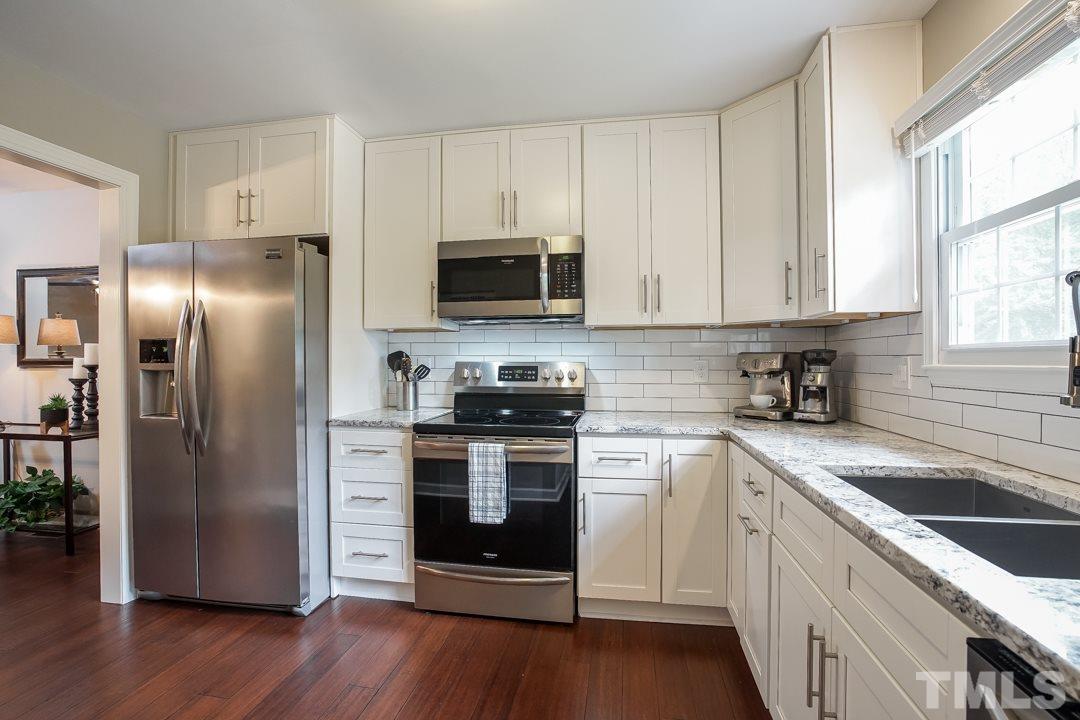 1318 Springlawn Court Raleigh, NC 27609 - Photo 8 of 30 a kitchen with a sink stove and refrigerator