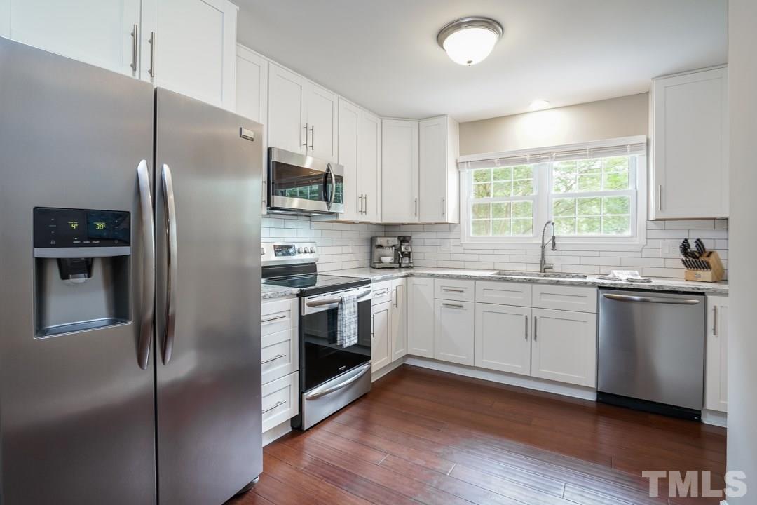 1318 Springlawn Court Raleigh, NC 27609 - Photo 9 of 30 a kitchen with granite countertop a refrigerator stove and sink