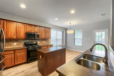a kitchen with a sink appliances and cabinets