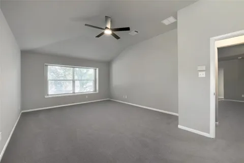 an empty room with a window and a fan